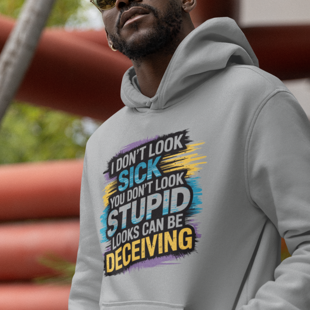 Man wearing a sports grey lupus awareness hoodie with bold text 'I Don’t Look Sick, You Don’t Look Stupid, Looks Can Be Deceiving'.