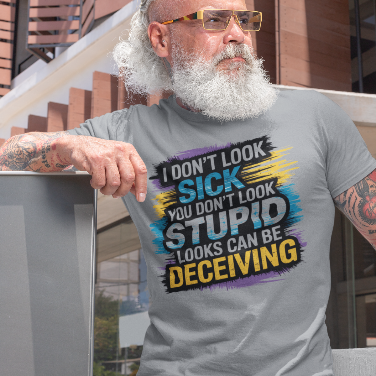 Man wearing a sports grey lupus awareness tee with bold text 'I Don’t Look Sick, You Don’t Look Stupid, Looks Can Be Deceiving'.