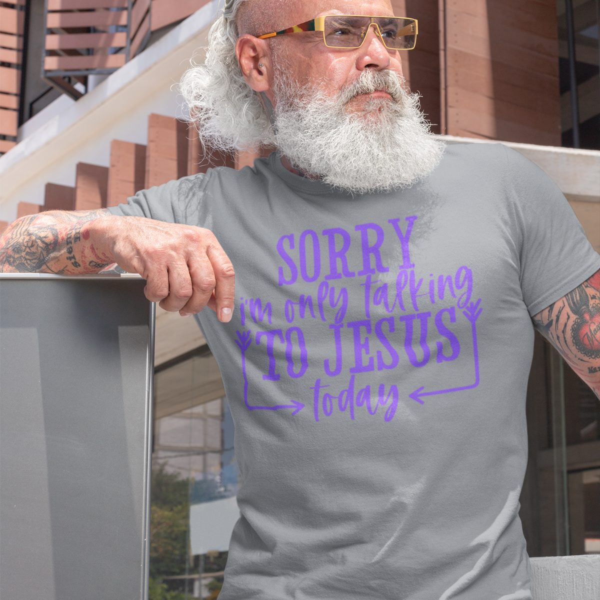 Man wearing a gray t-shirt with purple text 'SORRY i'm only talking TO JESUS today' outdoors.